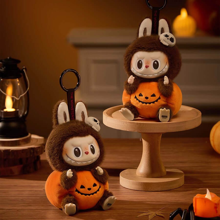 POPMART Happy Halloween Party Labubu Sitting Pumpkin Vinyl Plush Pendant 5 The Labubu Sitting Pumpkin plush pendant attached to the zipper of a black backpack